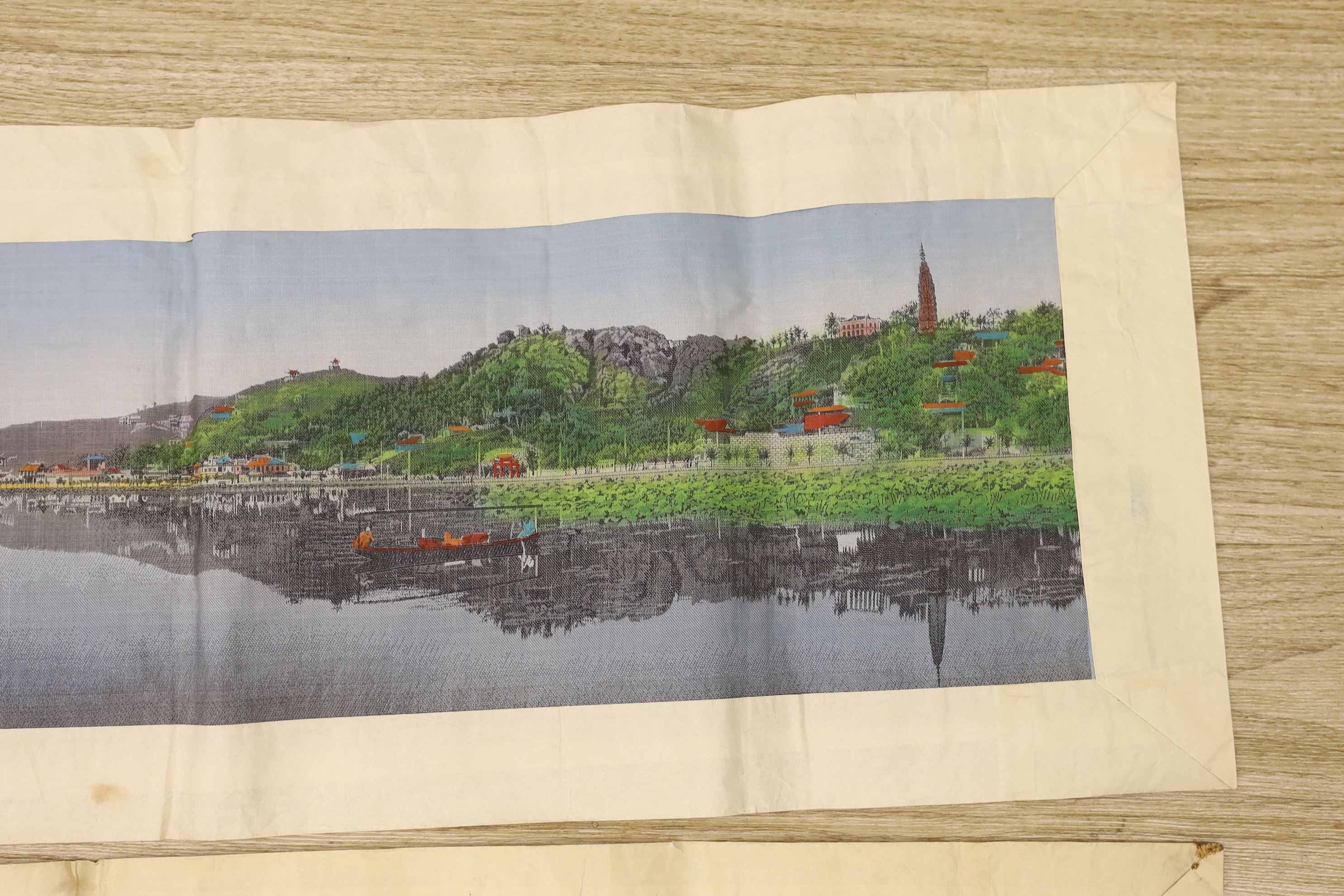 Two Chinese 1920’s machine silk panels, one depicting a contemporary Chinese coastline, the other a contemporary river scene, 71cm wide